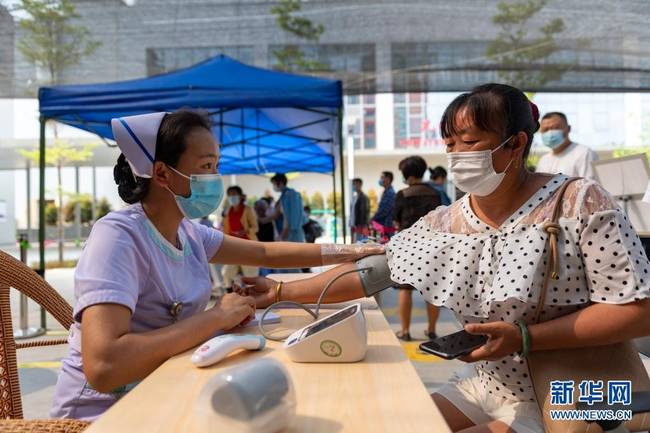 4月1日，一名女士在瑞丽市景成医院新冠疫苗接种点测量血压。